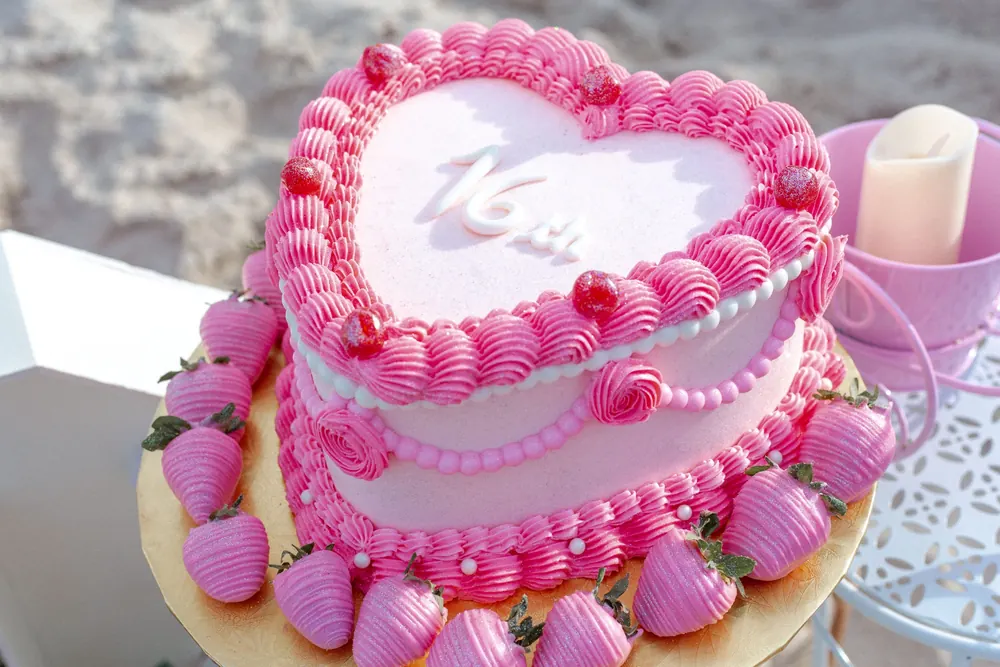 A pink heart cake with strawberries for a cake smash